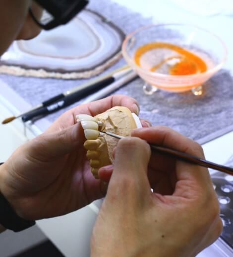 陶材を築盛する歯科技工士の手元